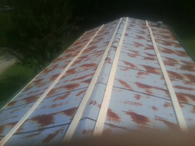Rusted metal roof panels with new wood purlins before replacement — Storm Damage Roof Repair in Watson by Roofing Brothers